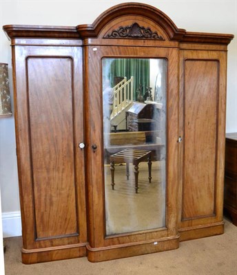 Lot 1476 - ^ A Victorian mahogany breakfront three drawer wardrobe with moulded cornice above a central mirror