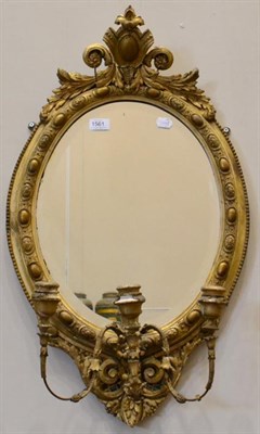 Lot 1561 - A 19th century gilt and gesso three-branch girandole with oval mirror plate, 76cm high