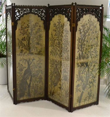 Lot 1568 - ^ A late 19th century mahogany four fold dressing screen with fret carved decoration above four...