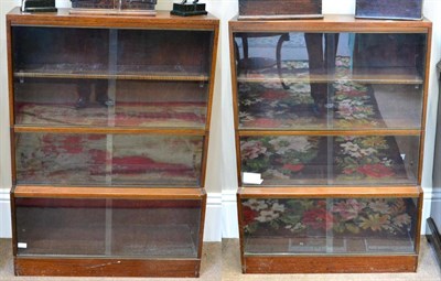 Lot 1612 - ^ A pair of early 20th century mahogany sectional bookcases, in three parts, with sliding glass...