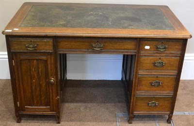 Lot 1621 - ^ An Edwardian oak desk, early 20th century, with green leather top, with six drawers and a...