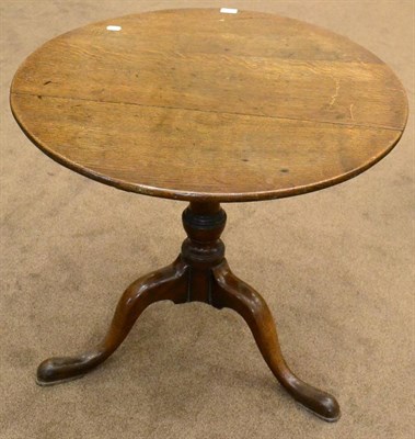 Lot 1636 - A George III oak flip top tripod table, late 18th century, with circular top above varsey...