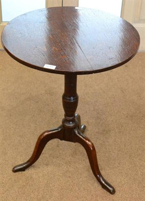 Lot 1639 - A George III oak tripod table, late 18th century with circular flip top raised on a varsey form...