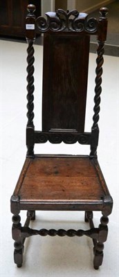 Lot 1641 - A joined oak backstool, early 18th century, with C scroll carved top rail above a fielded panel...