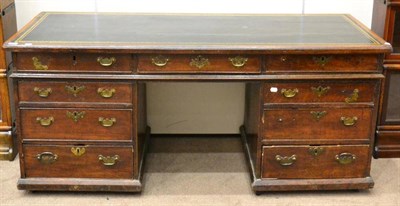 Lot 1649 - A late George III oak double pedestal writing desk, later green and gilt leather writing...