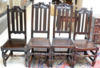 Lot 1650 - A matched set of four oak backstools, early 18th century, with C scroll top rails and fluted splats