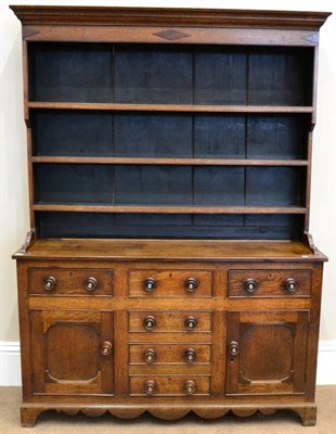 Lot 1673 - Late George III oak and mahogany cross banded dresser and rack, North Wales region, the base of...