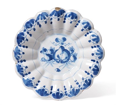 Lot 47 - A Delft Dish, circa 1700, of fluted circular form, painted in blue with fruit within a foliate...
