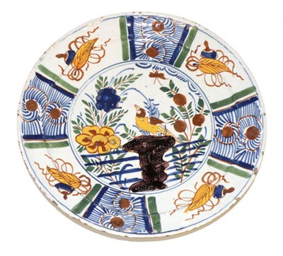 Lot 48 - A Delft Pancake Plate, circa 1760, painted in colours with a bird amongst foliage and rockwork...