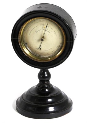 Lot 125 - ^ An Ebonised Desk Aneroid Barometer, circa 1890, circular hinged top raised upon a turned...