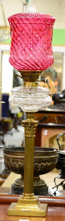 Lot 328 - A Brass Corinthian Column Oil Lamp, cranberry wrythen moulded glass shade, cut clear glass...