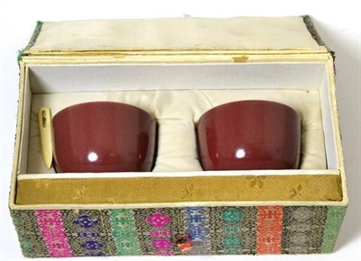 Lot 20 - A Pair of Chinese Sang de Boeuf Glazed Tea Bowls, Qing Dynasty, 6cm diameter, in presentation box