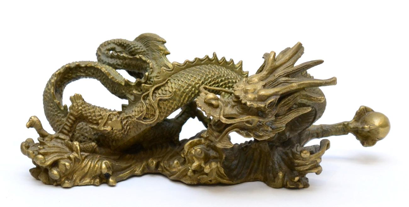 Lot 90 - A Chinese Bronze Dragon, Qing Dynasty, of wythen fluted form holding a pearl in its forepaw,...