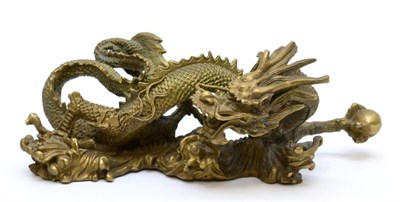 Lot 90 - A Chinese Bronze Dragon, Qing Dynasty, of wythen fluted form holding a pearl in its forepaw,...