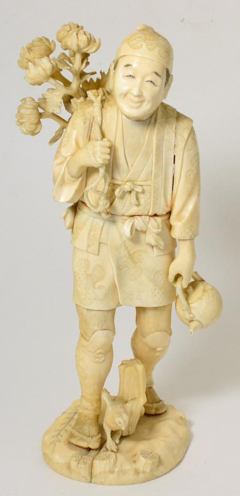 Lot 96 - A Japanese Sectioned Ivory Okimono of a Merchant, Meiji period, carrying a kettle in his left...