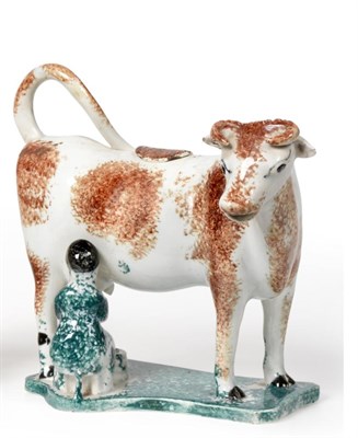 Lot 195 - A Pearlware Cow Creamer and Stopper, early 19th century, the standing beast with brown sponged...