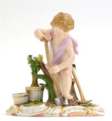 Lot 243 - A Meissen Porcelain Figure of a Cherub Gardener, circa 1900, with a spade and rake, plant pots...