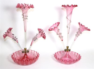 Lot 302 - A Cranberry Glass Epergne, with frilled rim, the central trumpet vases flanked by two further...