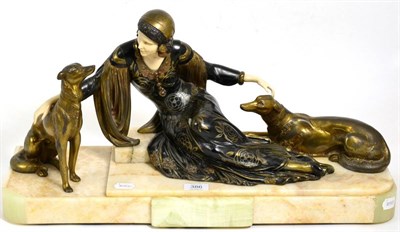 Lot 386 - An Art Deco Style Ivorine and Spelter Figure Group, as a lady in flapper costume with two dogs,...