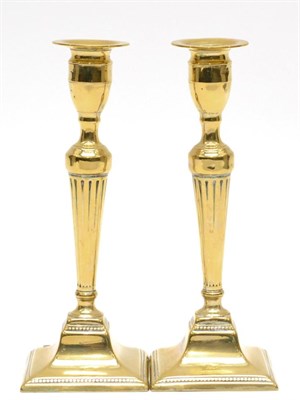 Lot 406 - A Pair of George III Brass Candlesticks, with urn sconces, fluted tapering columns and square...