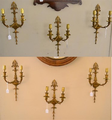 Lot 422 - A Set of Six Gilt Metal Twin-Light Wall Sconces, in George III style, cast with anthemion, urns and