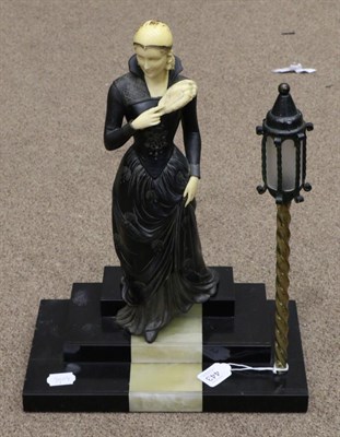 Lot 443 - An Art Deco Style Spelter and Ivorine Figure of a Lady, in flowing dress, on a stepped marble...