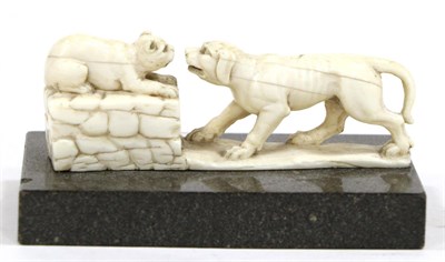 Lot 451 - A Continental Ivory Group of a Cat and Dog, late 19th century, the cat on a stone wall, on a...