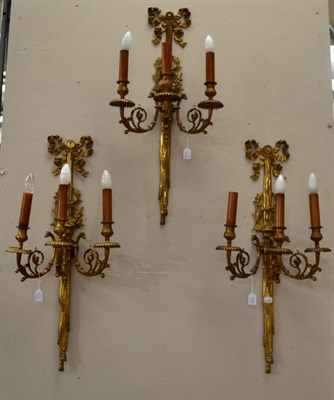 Lot 527 - A Set of Three 19th Century Ormolu Three-Branch Wall Appliques, each backplate surmounted by ribbon