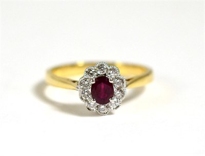 Lot 592 - A Ruby and Diamond Cluster Ring, a round cut ruby in a claw setting, within a border of round...