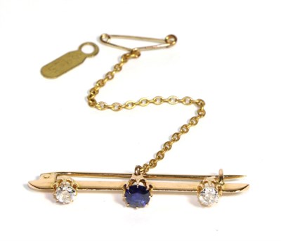 Lot 608 - A Sapphire and Diamond Bar Brooch, a round cut sapphire to a knife edge bar terminating in two...