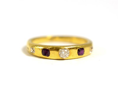 Lot 656 - A Ruby and Diamond Band Ring, inset with three graduated old cut diamonds spaced by two step...