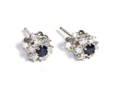 Lot 669 - A Pair of Sapphire and Diamond Cluster Earrings, a round cut sapphire within a border of six...