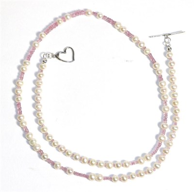 Lot 677 - A Pink Sapphire and Cultured Pearl Necklace, graduated faceted pink sapphire beads spaced at...