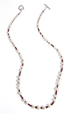 Lot 678 - A Ruby and Cultured Pearl Necklace, graduated faceted ruby beads spaced at intervals by groups...