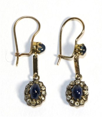 Lot 687 - A Pair of Sapphire and Diamond Cluster Drop Earrings, an oval cabochon sapphire in a claw settings