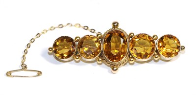 Lot 708 - A Citrine Brooch, an oval cut citrine in a collet setting, within a rope and beaded border, flanked