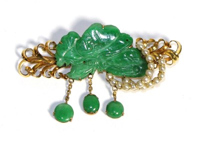 Lot 711 - A Jade and Seed Pearl Brooch, a carved jade plaque within a scroll work frame set with two bands of