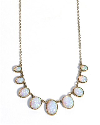 Lot 720 - A 9 Carat Gold Synethtic Opal Necklace, graduated oval cabochon opals in rubbed over settings...