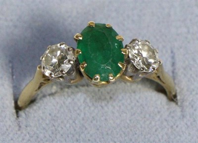 Lot 727 - An Emerald and Diamond Three Stone Ring, an oval cut emerald between two round brilliant cut...