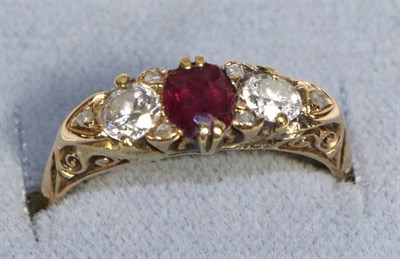 Lot 750 - An 18 Carat Gold Ruby and Diamond Three Stone Ring, an oval cut ruby between two old cut...