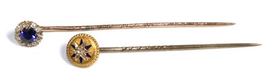 Lot 759 - A Sapphire and Diamond Stick Pin, a round cut sapphire within a border of old cut diamonds,...