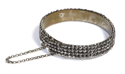 Lot 770 - An Antique Cut Steel Bangle, as four rows of faceted steel studs, measures 6cm by 5cm inner...