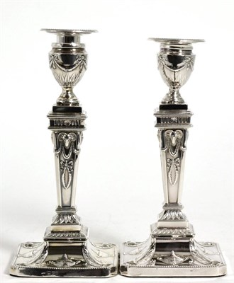 Lot 778 - A Pair of Edwardian Silver Candlesticks of George III Style, William Neale, Chester 1904, decorated