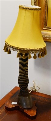 Lot 1054 - A Zebra Foreleg Mounted Table Lamp, with yellow silk shade, mounted upon an Africa shaped...