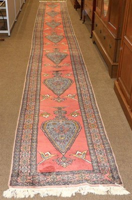 Lot 1128 - Narrow Indian Runner, circa 1970 The brick red field with a column of urns issuing flowers enclosed