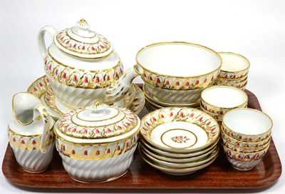 Lot 32 - A Coalport Porcelain Tea Service, circa 1800, of wrythen fluted form, painted with red and gilt...