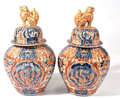 Lot 199 - A Pair of Imari Porcelain Jars and Covers, Meiji period, of fluted baluster form with shi-shi...