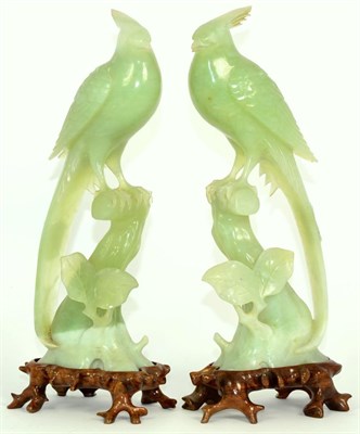 Lot 212 - A Pair of Chinese Jade Models of Birds, each perched on a tree stump, 26cm high, on hardwood stands