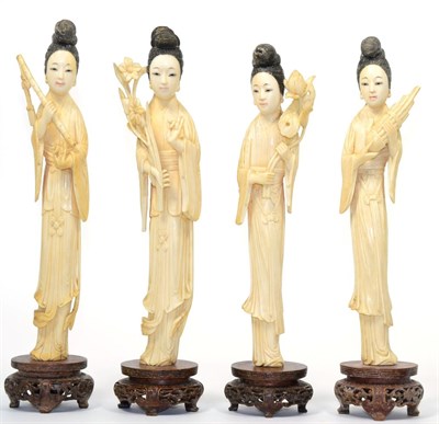 Lot 234 - A Set of Four Chinese Ivory Figures of Maidens, circa 1920, each standing wearing long robes...