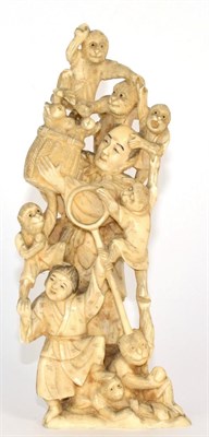 Lot 241 - A Japanese Ivory Okimono, Meiji period, as a monkey trainer and assistant holding a basket...